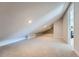 Finished attic space with neutral carpet, recessed lighting, and a unique sloped ceiling at 15290 W 69Th Pl, Arvada, CO 80007