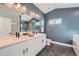 Modern bathroom featuring a double vanity, sleek black hardware, and a large mirror at 15290 W 69Th Pl, Arvada, CO 80007