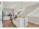 Open kitchen layout with an island, stainless steel appliances, and a view of the staircase at 15290 W 69Th Pl, Arvada, CO 80007