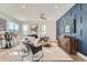 Stylish living room with a blue accent wall, modern furniture, and ample natural light at 15290 W 69Th Pl, Arvada, CO 80007