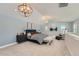 Spacious main bedroom with a blue accent wall, elegant lighting, and a seating area at 15290 W 69Th Pl, Arvada, CO 80007
