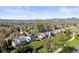 Wide aerial shot capturing the home's location in a treed neighborhood with mountain views in the distance at 10895 W Bowles Pl, Littleton, CO 80127