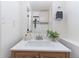 Bathroom offering a single sink vanity, neutral finishes, modern fixtures, and a decorative plant at 10895 W Bowles Pl, Littleton, CO 80127