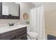 Bathroom featuring a wood vanity, decorative mirror, and a shower/tub combo with a white curtain at 10895 W Bowles Pl, Littleton, CO 80127