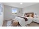 Neutral bedroom with a window, bed with brown accents, and decorative stools on an eye-catching carpet at 10895 W Bowles Pl, Littleton, CO 80127