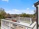 View of the deck with outdoor seating and flower pot overlooking a treed yard and blue sky at 10895 W Bowles Pl, Littleton, CO 80127