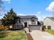 Inviting two-story home with grey siding, stone accents, and an attached two-car garage at 10895 W Bowles Pl, Littleton, CO 80127