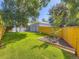 Lush backyard with green lawn, mature trees, and a well-maintained fence at 1350 E Amherst Ave, Englewood, CO 80113