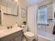 Well-maintained bathroom featuring a shower-tub combo and a glass block window at 1350 E Amherst Ave, Englewood, CO 80113