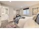 Basement bedroom features an accent chair, a large bed and two windows at 1350 E Amherst Ave, Englewood, CO 80113