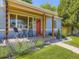 Close-up view of the front porch with brick steps, a red door and decorative landscaping at 1350 E Amherst Ave, Englewood, CO 80113