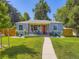 Charming blue home with a red door, a landscaped front yard and cozy porch seating at 1350 E Amherst Ave, Englewood, CO 80113
