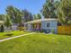Quaint blue home with well-manicured lawn, fenced yard, cozy porch and vibrant landscaping at 1350 E Amherst Ave, Englewood, CO 80113