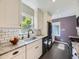 Bright kitchen with granite countertops, white cabinets, subway tile backsplash, and modern appliances at 1350 E Amherst Ave, Englewood, CO 80113