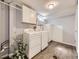 Functional laundry room with white washer, dryer, cabinets, and wood-look flooring at 1350 E Amherst Ave, Englewood, CO 80113