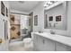 Well-lit bathroom with a glass enclosed shower, gray vanity, and modern fixtures at 7819 Tejon St, Denver, CO 80221