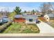 Exterior front view of home with green lawn and driveway on a sunny day at 7819 Tejon St, Denver, CO 80221
