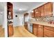 Charming kitchen featuring wood cabinets, stainless steel appliances, and warm wood floors at 7819 Tejon St, Denver, CO 80221