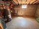 Unfinished basement area with concrete floor, exposed ceiling, and small window at 660 Wolff St, Denver, CO 80204