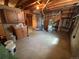 Unfinished basement with concrete floor, wooden cabinetry, and doorway to another area at 660 Wolff St, Denver, CO 80204