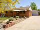 Charming brick home featuring a well-kept front yard and an inviting entrance with awning at 660 Wolff St, Denver, CO 80204