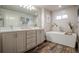 Modern bathroom featuring double vanity, soaking tub, and wood-look floors for a luxurious retreat at 12254 Hazel Spruce Ct, Parker, CO 80134