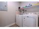 Bright laundry room equipped with modern white appliances, shelving, and ample storage space at 12254 Hazel Spruce Ct, Parker, CO 80134