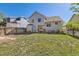 Grassy backyard, enclosed by a wood fence, features a small patio with outdoor seating, and home's exterior at 13069 Jackson Dr, Thornton, CO 80241