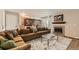 Open living room area, featuring a large sectional, glass table, fireplace, and view of the kitchen at 13069 Jackson Dr, Thornton, CO 80241