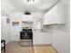 Compact kitchen with stainless steel appliances, white cabinetry, and a cozy breakfast nook at 3740 W Exposition Ave, Denver, CO 80219