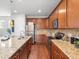 Well-lit kitchen featuring granite counters, stainless appliances, and wood floors at 1344 S Coolidge Cir, Aurora, CO 80018