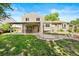 Well-maintained backyard featuring a covered patio, stone firepit, and lush green lawn for outdoor enjoyment at 11530 Elm Ct, Thornton, CO 80233