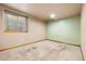 Basement room with carpet and mint walls, featuring a window and electrical outlets at 11530 Elm Ct, Thornton, CO 80233