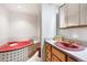 Bathroom with a corner tub and vanity with sink, all in coordinating shades of pink at 11530 Elm Ct, Thornton, CO 80233