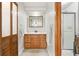 Bathroom featuring a wood vanity and cabinet with an enclosed shower, and a sliding wood door at 11530 Elm Ct, Thornton, CO 80233