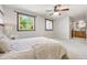 Bright bedroom with a fan and windows featuring a private bathroom with a wood vanity at 11530 Elm Ct, Thornton, CO 80233