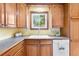 Well-maintained kitchen featuring wooden cabinetry, white appliances, neutral countertops, and natural light at 11530 Elm Ct, Thornton, CO 80233