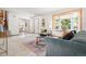 Spacious living room with a large bay window, white walls, and access to the staircase at 11530 Elm Ct, Thornton, CO 80233