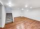 Finished basement with hardwood floors and a staircase with white banister at 3061 W 92Nd Ave # 11B, Westminster, CO 80031