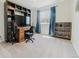 Bedroom with a large window with blue curtains, a desk, and a carpeted floor at 15389 E 99Th Way, Commerce City, CO 80022