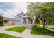 A beautiful two-story home with gray siding and a covered porch. Nicely landscaped front yard and two car garage at 15389 E 99Th Way, Commerce City, CO 80022