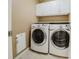 Well-equipped laundry room with modern washer and dryer units and cabinet storage at 15389 E 99Th Way, Commerce City, CO 80022