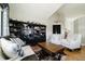 Cozy living room with wood floors, large bookshelf, and comfortable seating area with lots of natural light at 15389 E 99Th Way, Commerce City, CO 80022