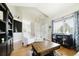 Bright living room featuring wood floors, high ceilings and large windows offering views of the landscaped yard at 15389 E 99Th Way, Commerce City, CO 80022