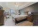 Spacious main bedroom featuring a tray ceiling, a large bed, and wooden furniture at 15389 E 99Th Way, Commerce City, CO 80022