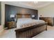 Spacious main bedroom featuring a tray ceiling, a large bed, and wooden furniture at 15389 E 99Th Way, Commerce City, CO 80022