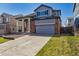 Two story home with brick accents, gray siding, large front yard and attached two car garage at 16006 E 97Th Pl, Commerce City, CO 80022