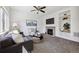 Bright living room with fireplace, ceiling fan, and built-in shelving, offering a cozy and inviting space at 16006 E 97Th Pl, Commerce City, CO 80022