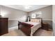 Cozy bedroom featuring a comfortable sleigh bed, neutral color scheme, and natural light from the window at 11053 Meadowvale Cir, Highlands Ranch, CO 80130