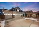 Charming two-story home with a three-car garage, brick accents, and landscaped front yard at twilight at 11053 Meadowvale Cir, Highlands Ranch, CO 80130